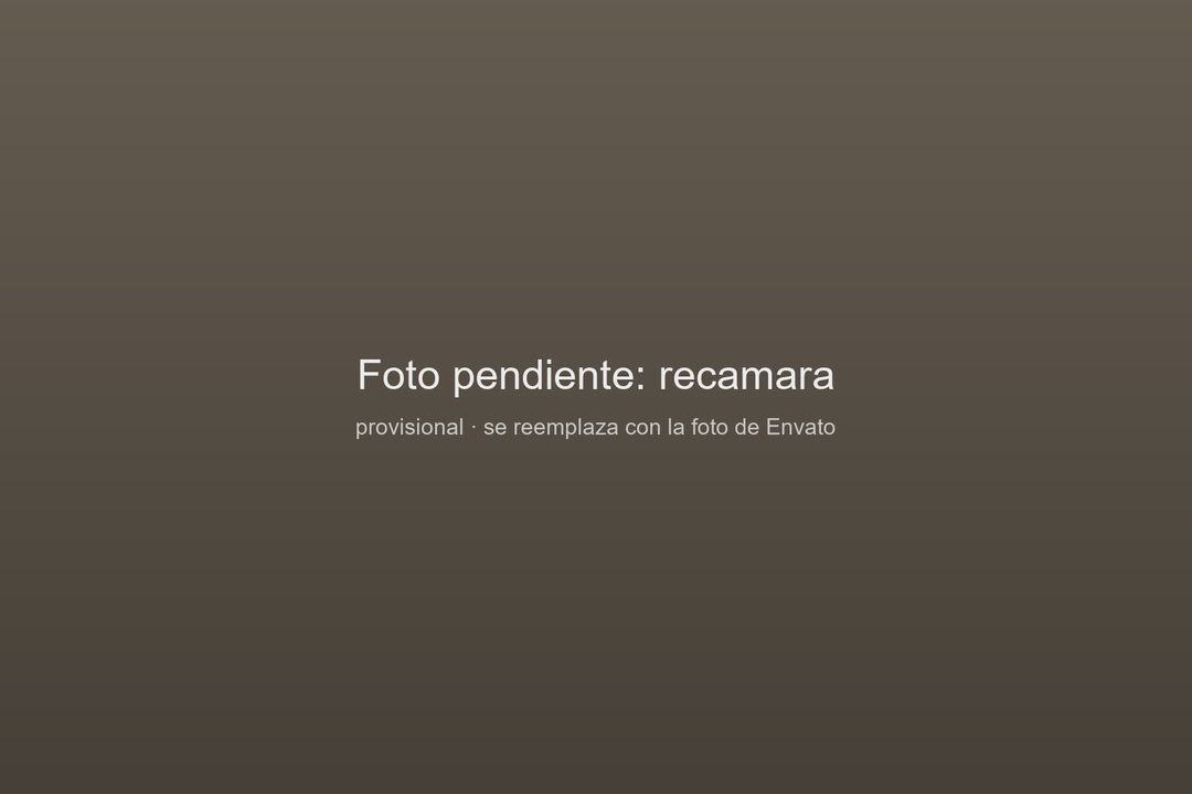 Recámara principal con ropa de cama clara y madera